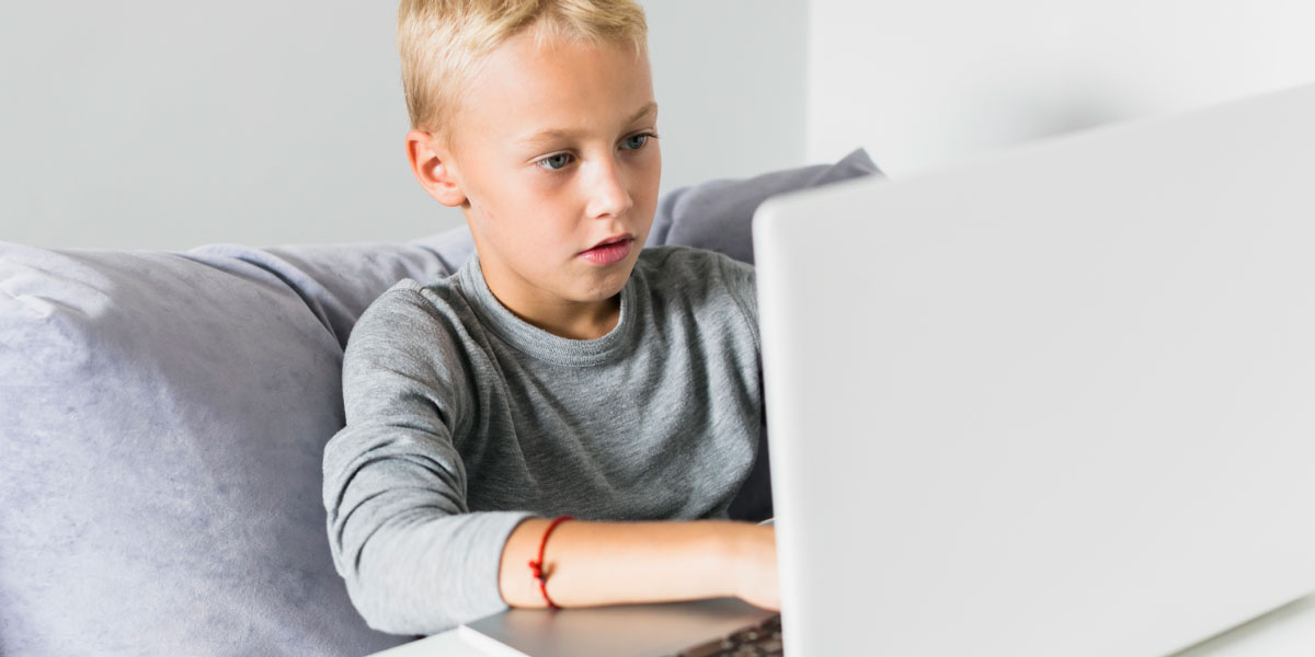 Boy sitting in front of a laptop