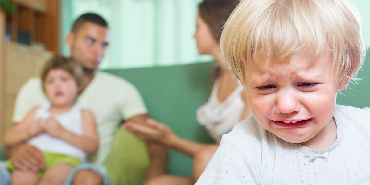 Child crying with family in the background