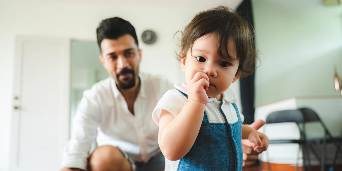 Toddler turning his back on his father not listening to him and picking nose