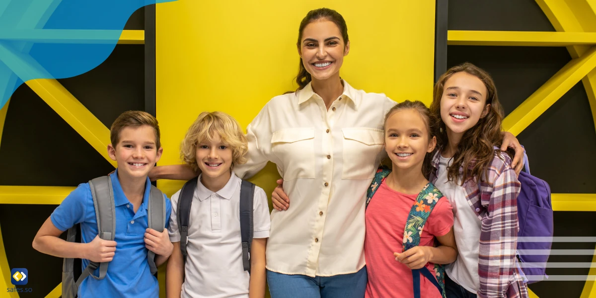 Students hugging their teachers obviously happy to attend school