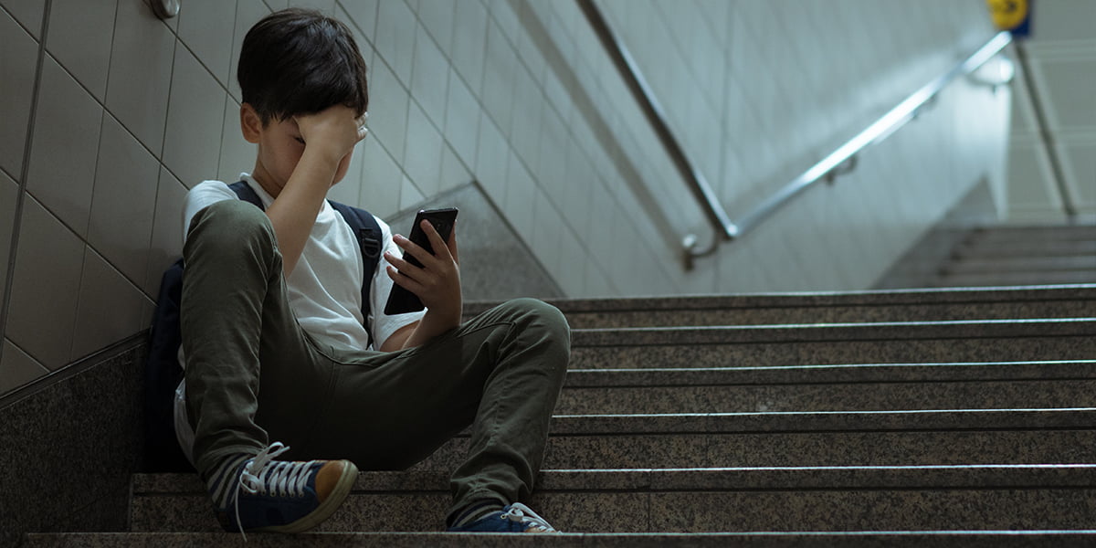 boy sitting at stair effected by cyberbullying in socialmedia platforms