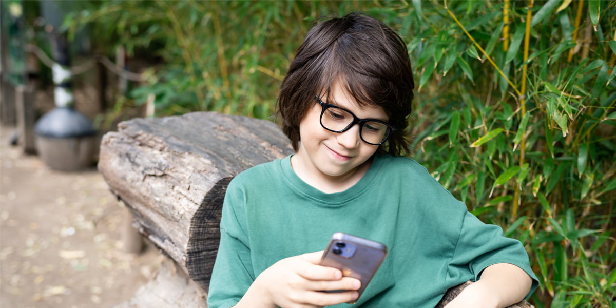 smiling child looking at his phone