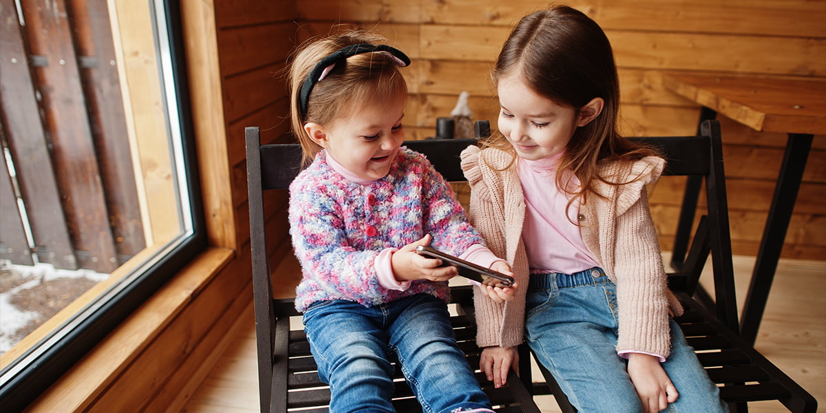 Two Sisters playing with a phone