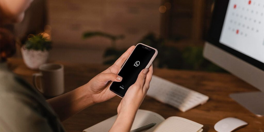 A Teenager with a Smartphone in Hand. WhatsApp Is Open on the Phone’s Screen.