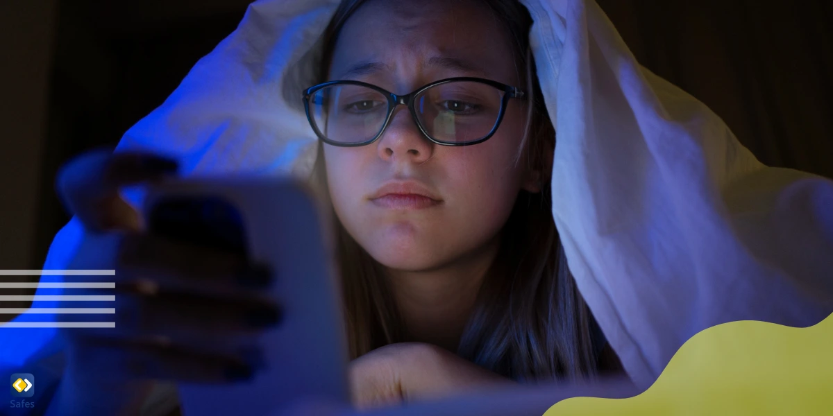 Teenage girl checking Snapchat late at night, her worried exposure is the telltale of receiving troublesome Snaps.