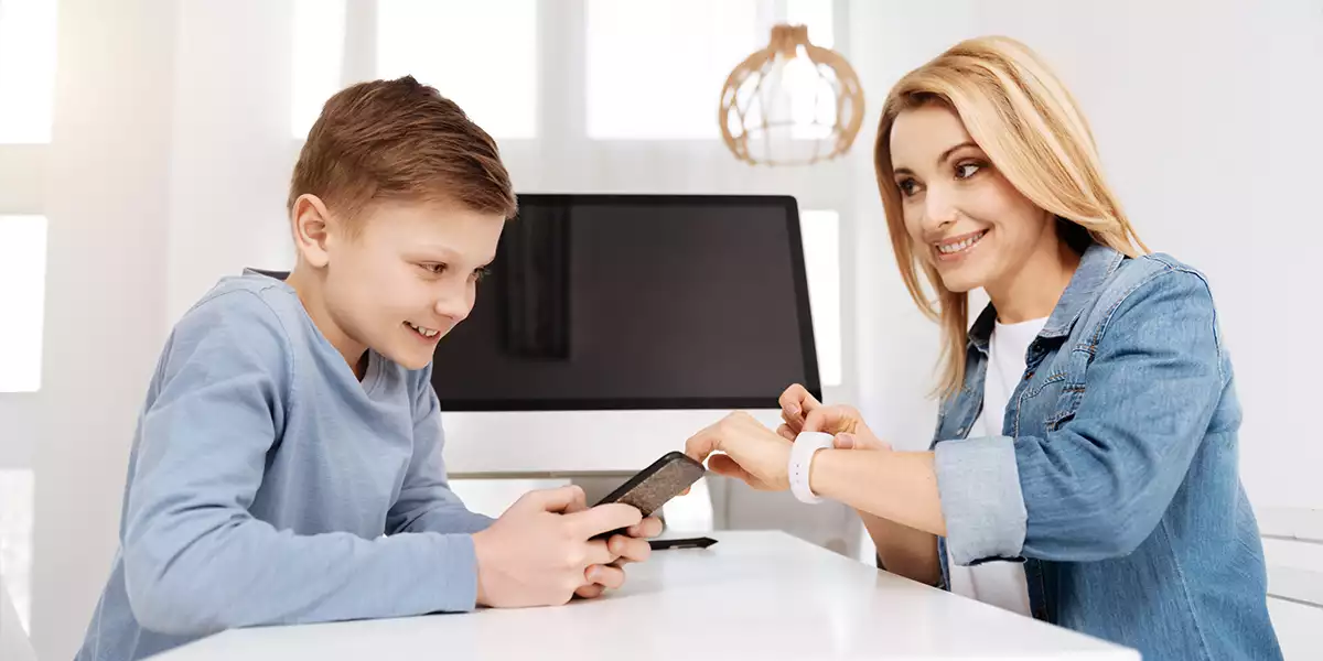 parent pointing at her watch as a time is up gesture