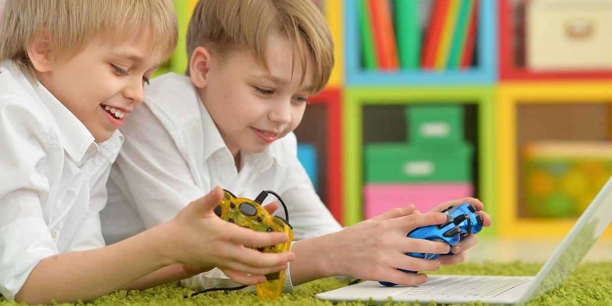 Two young boys playing games on a laptop