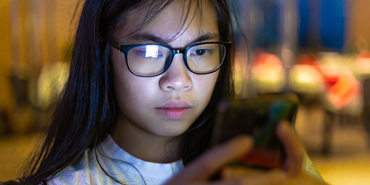 Young teenager using social media through her phone