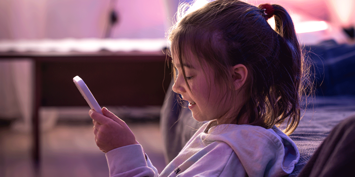 A little girl is using her phone addictively