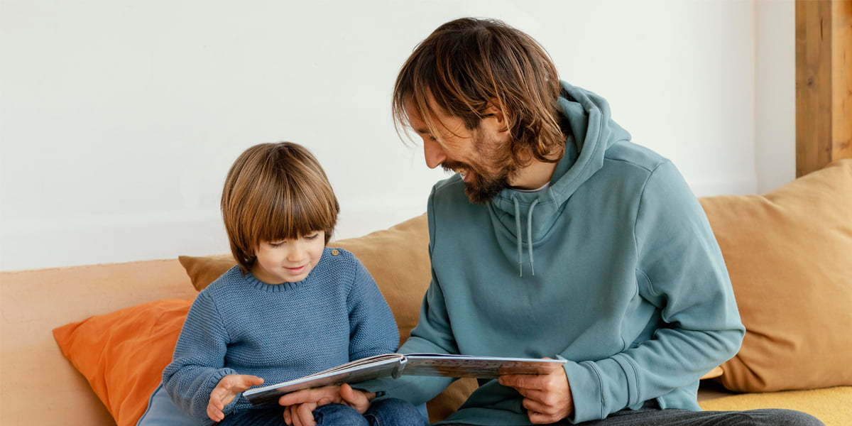 A father reading a children’s book about internet safety to his young son