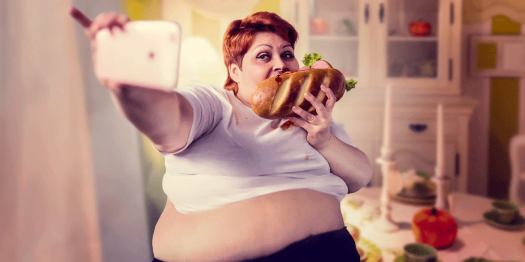 Obese woman eating a sandwich while taking a selfie