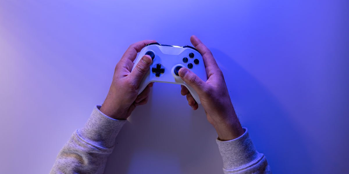 A person's hands holding a PS5 controller