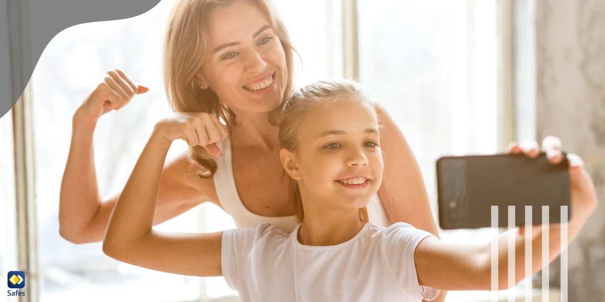 Mother and daughter taking a selfie while flexing muscles and smiling