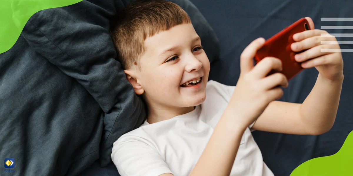 Kleiner Junge lächelt, während er auf einem Sofa telefoniert