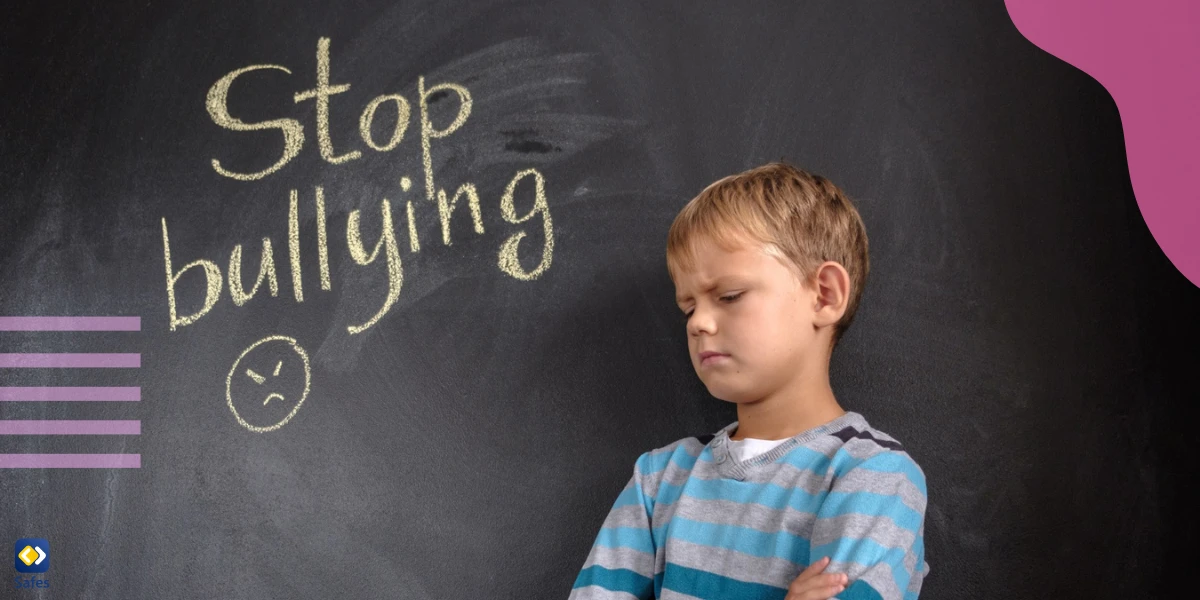 an angry little boy standing near a blackboard