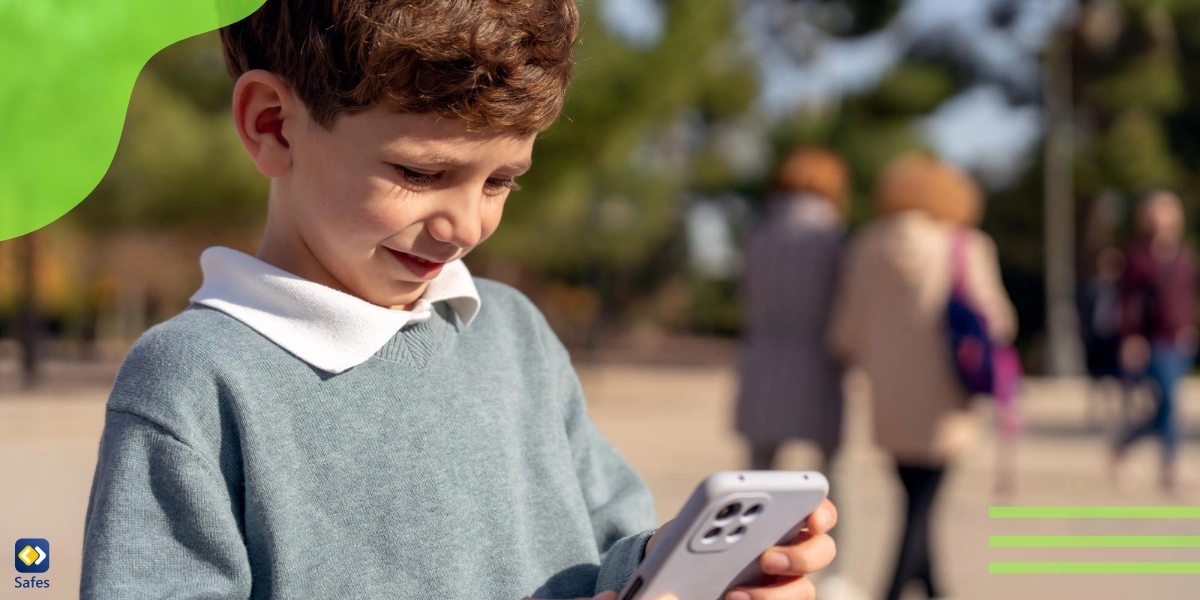 ein kleiner Junge benutzt ein Handy im Park