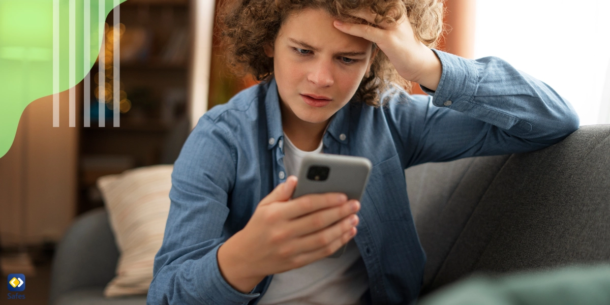 Stressed teenage boy looking at phone