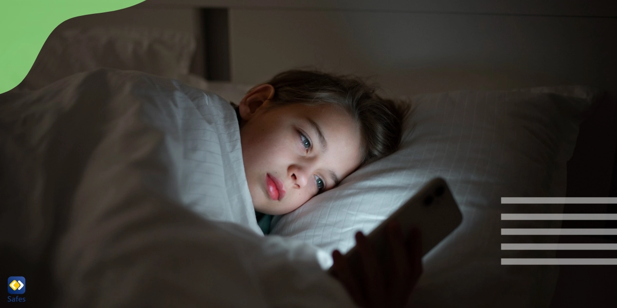 A little boy working with his smartphone in bed