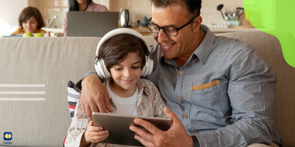 Kind undVaterTelefon benutzenund Mutter und Junge benutzen Laptop im Hintergrund