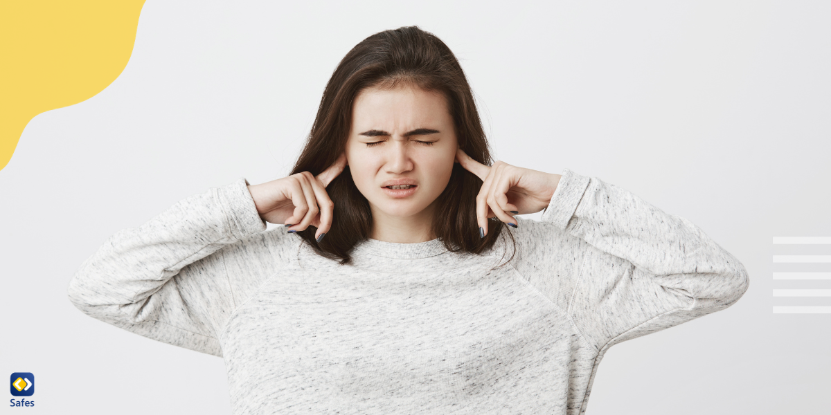 A girl putting her fingers in her ears to block out all the noise.