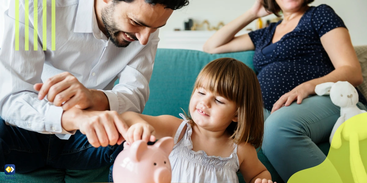 Parents teaching their young daughter how to save money in her piggy bank.