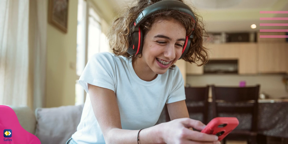 A teenager enthusiastically playing Candy Crush Saga on her mobile phone while wearing a headphone.