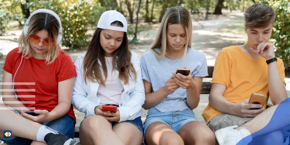 four teens playing with their cell phones