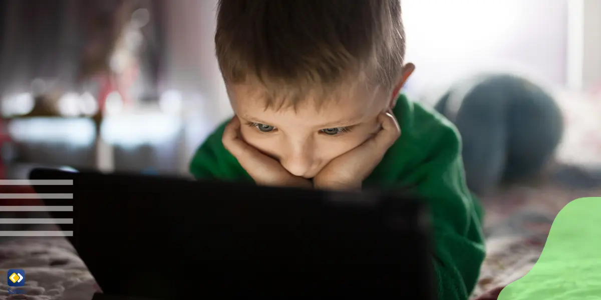 a young boy staring at a laptop screen watching inappropriate content on the internet.