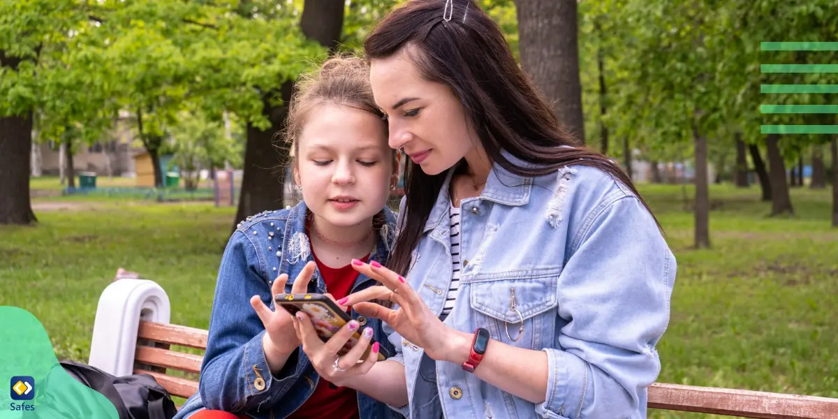 eine Mutter, die Zeit mit ihrer Tochter im Freien verbringt, während sie mit ihrem Handy spielt und eine gesunde digitale Diät für sie etabliert