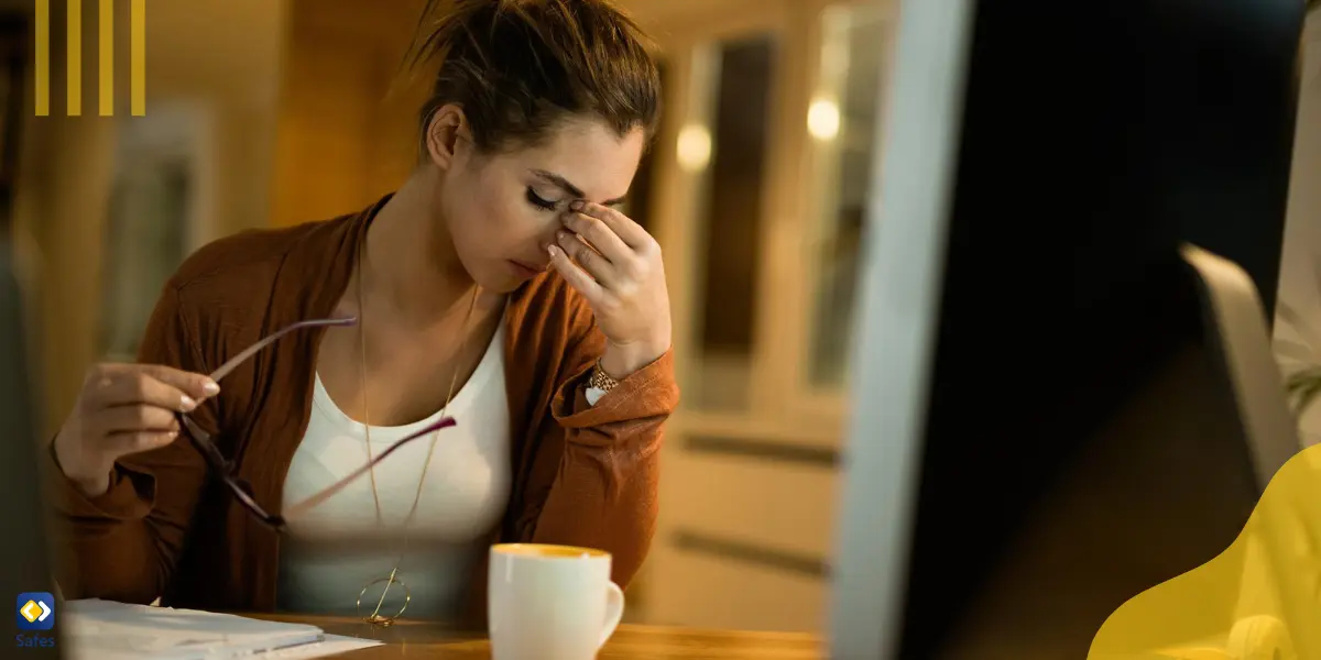 Displeased woman having a headache while working on desktop PC