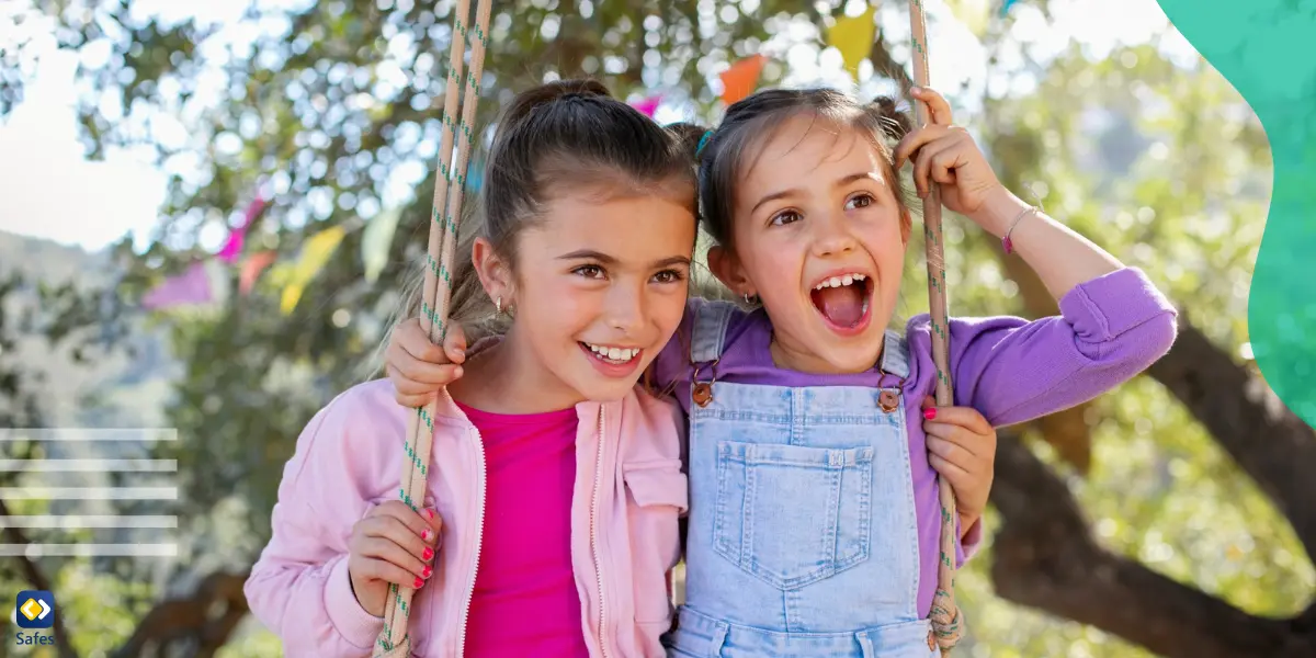 Two young girls sitting on a swing