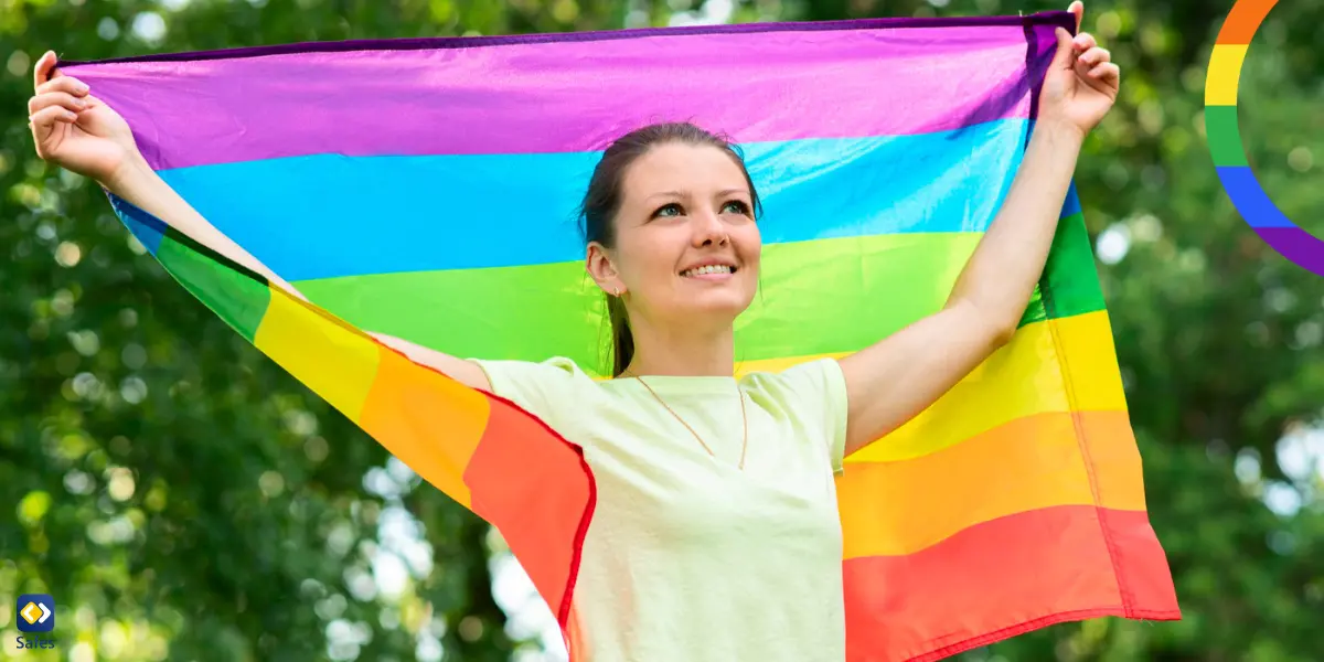 a non binary teen girl holding a rainbow flag