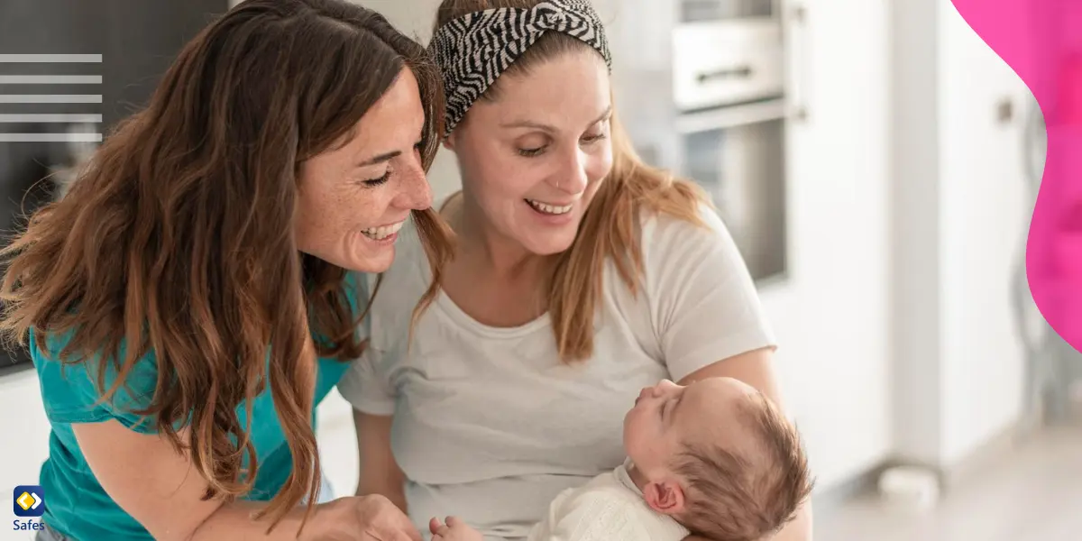 a mother is holding her baby while having her friend as a support next to her