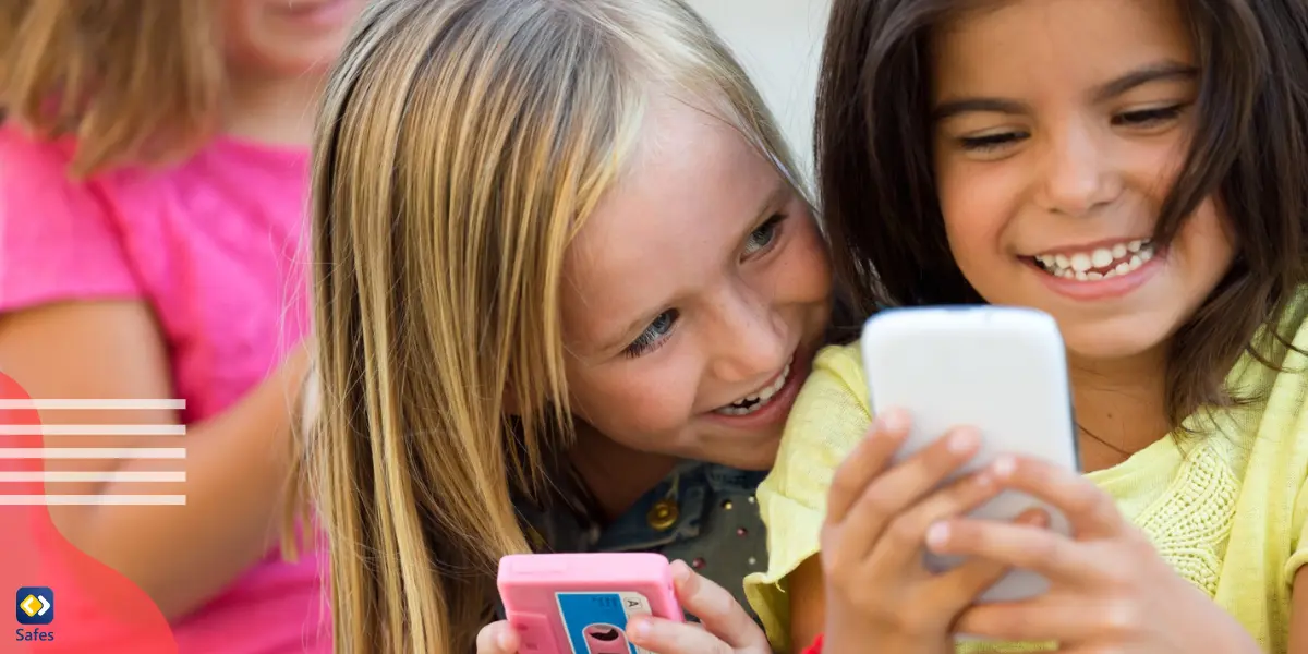 three young girls using their mobile phones and giggling with each other