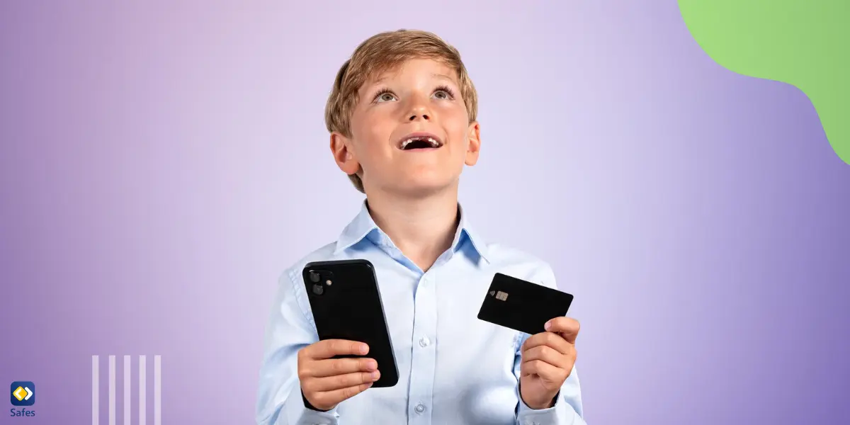 a young boy holding a phone in one hand and a credit card in another hand