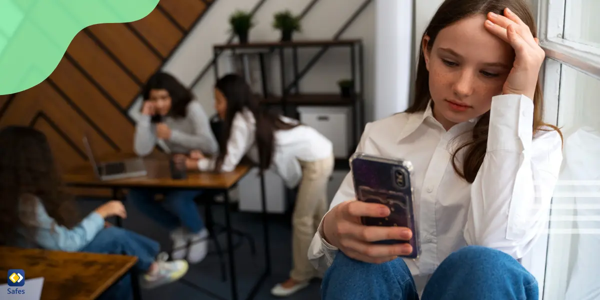 Girl being cyberbullied while using phone in class with other students talking