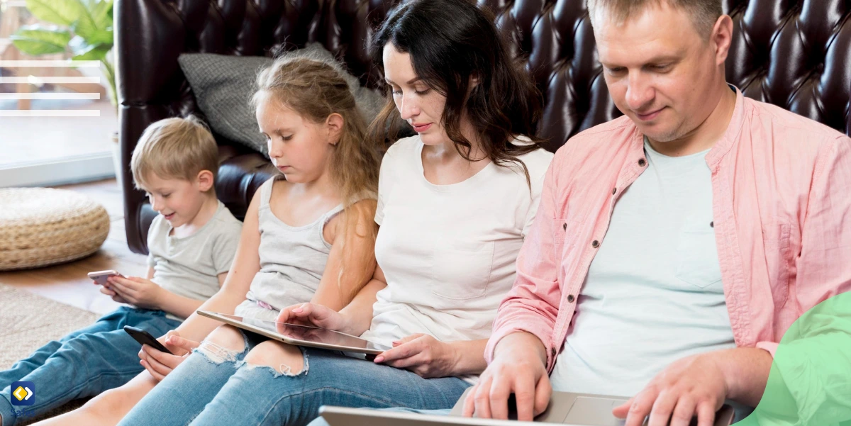 a family lying on the floor and using different digital devices.