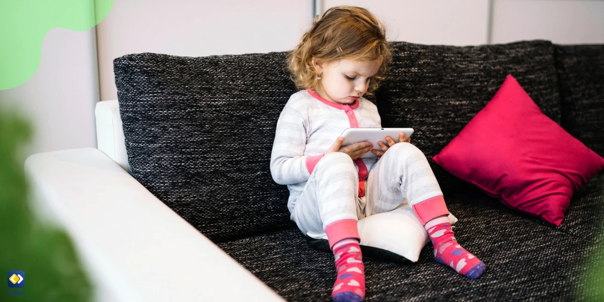 a girl using a tablet on a sofa