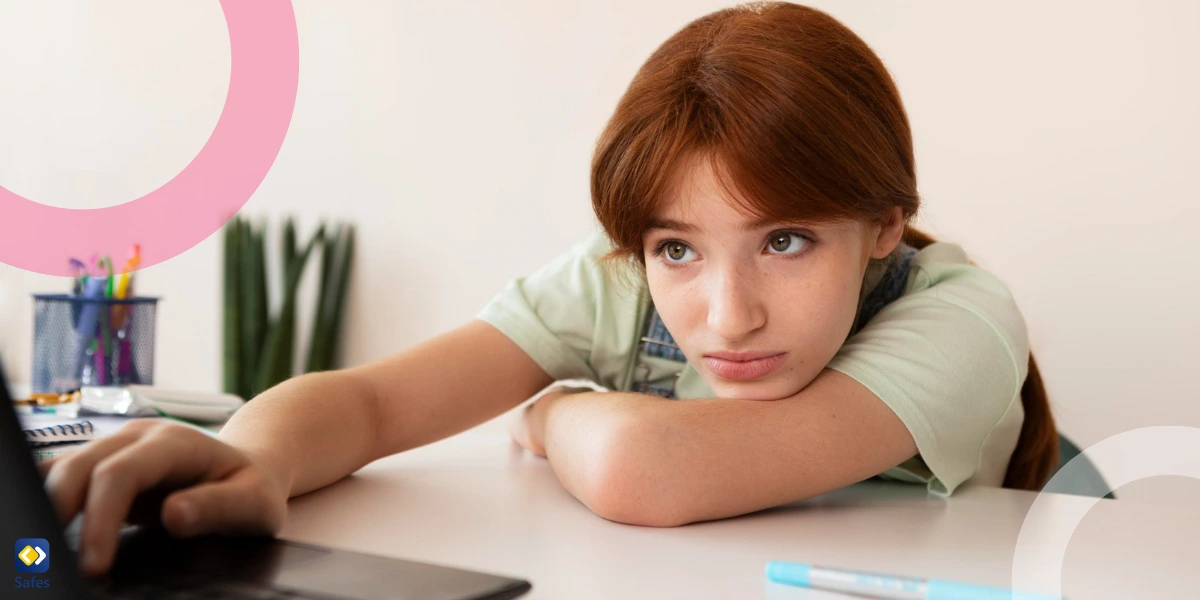 a teen girl looking at her laptop screen and is upset because of negative comments