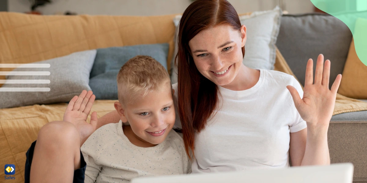 A mother and her son having a family Zoom video call, smiling and looking at a laptop screen together in a cozy home setting.