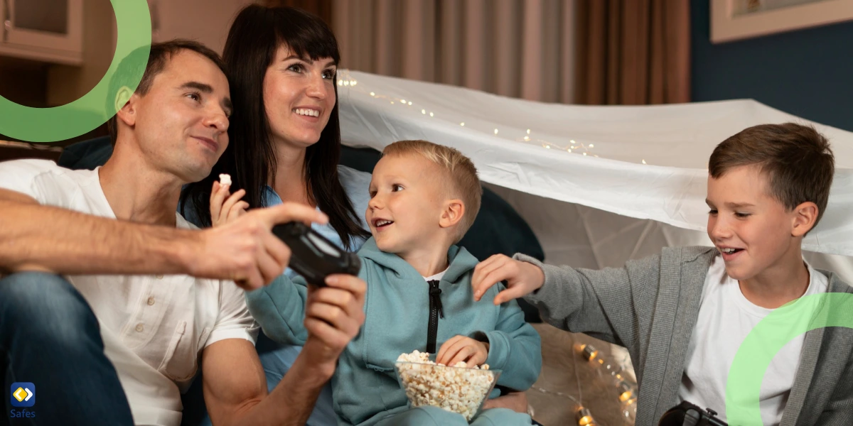 Eine vierköpfige Familie genießt einen Spieleabend und isst Popcorn