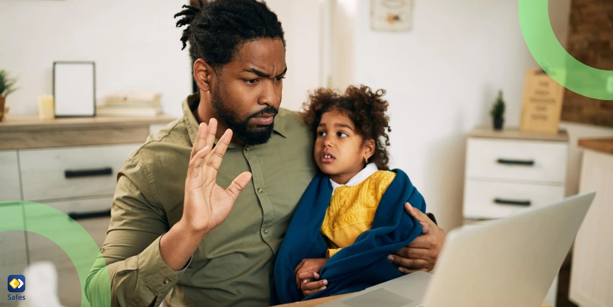 upset African American father with his daughter using a laptop