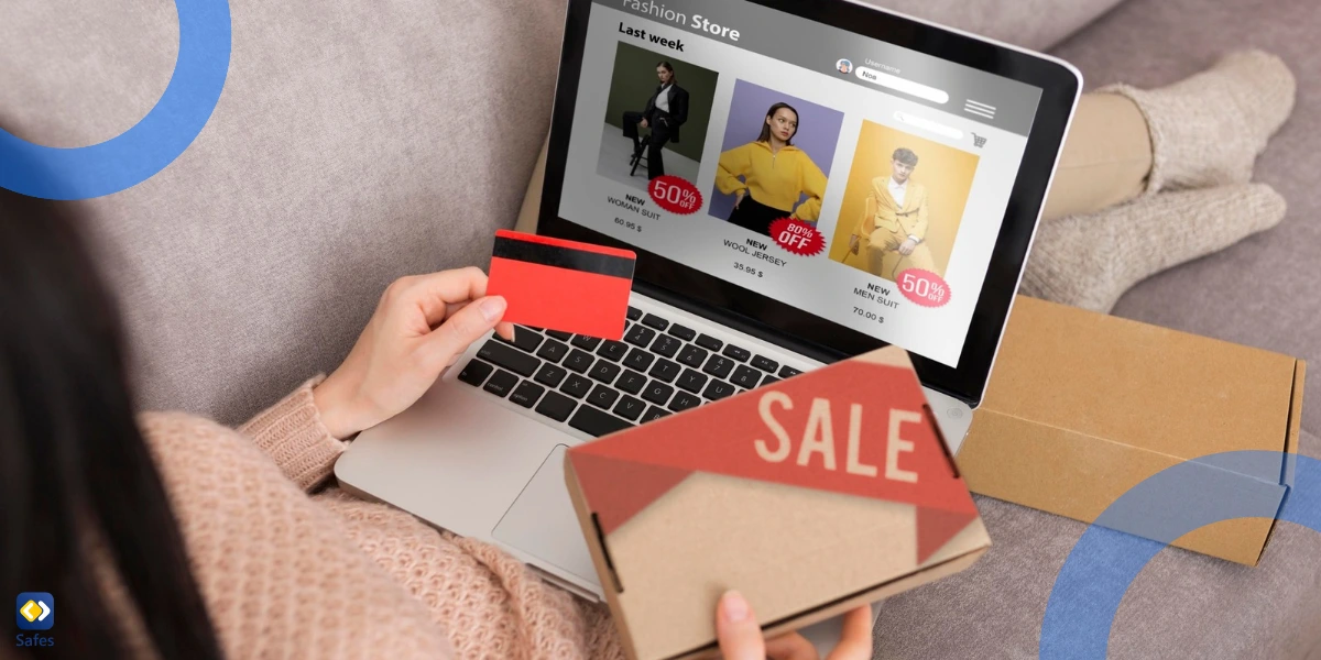 A person is lounging on a couch, shopping online using a laptop. They hold a credit card in one hand and a package in the other.