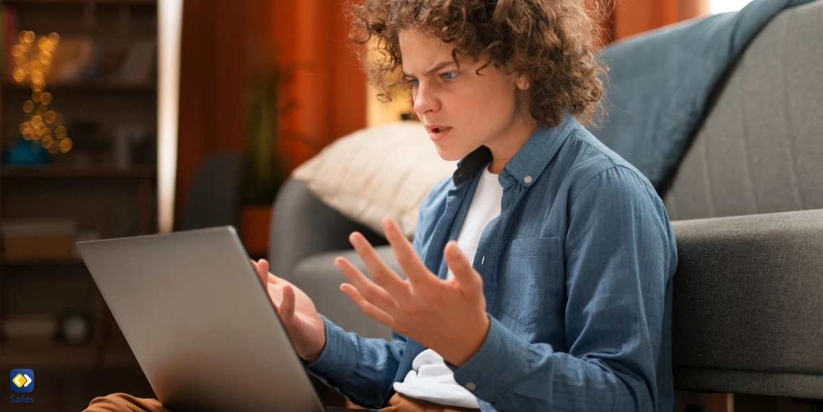 Teenager mit Laptop auf dem Schoß und verärgert und wütend