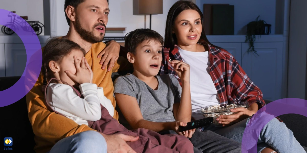 vierköpfige Familie mit schockiertem Gesichtsausdruck sieht sich einen Film an, wobei eines der Kinder ihre Augen bedeckt