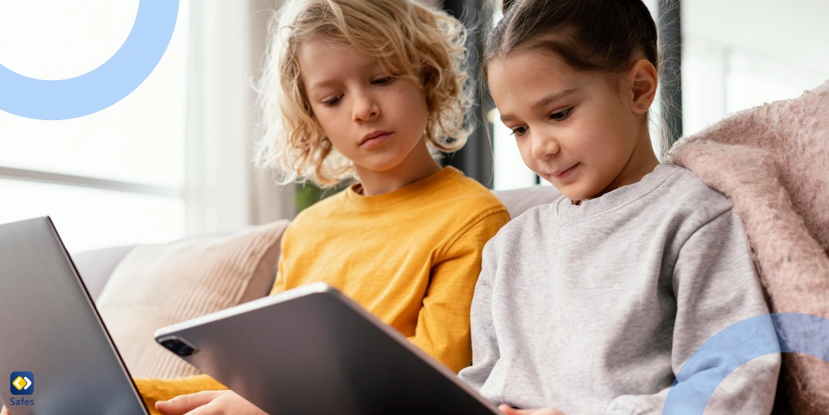 Siblings sitting on couch and using a laptop and tablet