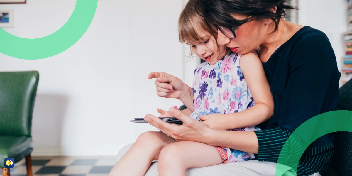 daughter sitting on mother's lap and using a tablet