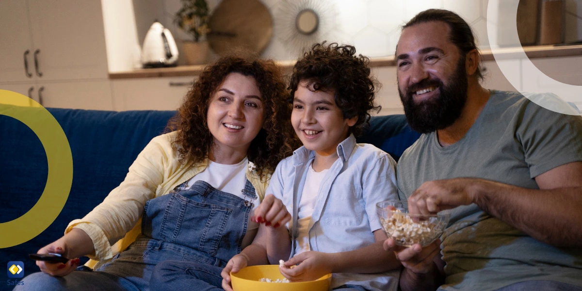 family of three watching TV with bowls of popcorn