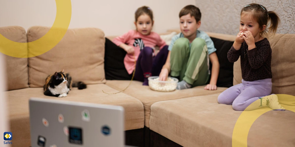 Kinder sitzen auf einer Couch im Wohnzimmer und schauen sich einen Film auf einem Laptop an