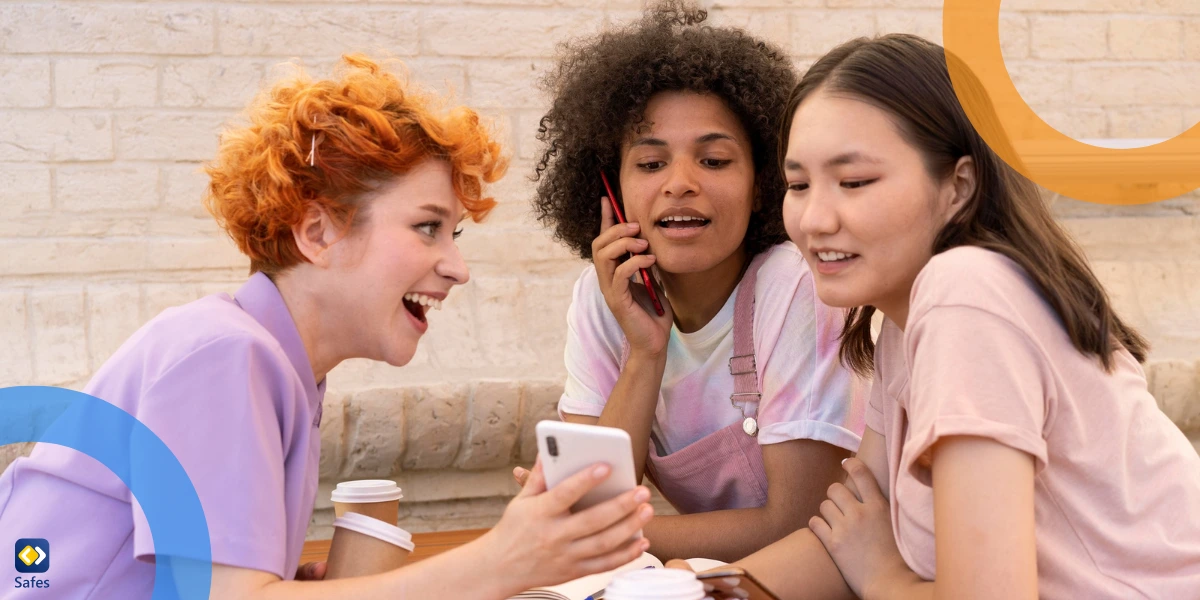 three teen girls showing eachother their phone